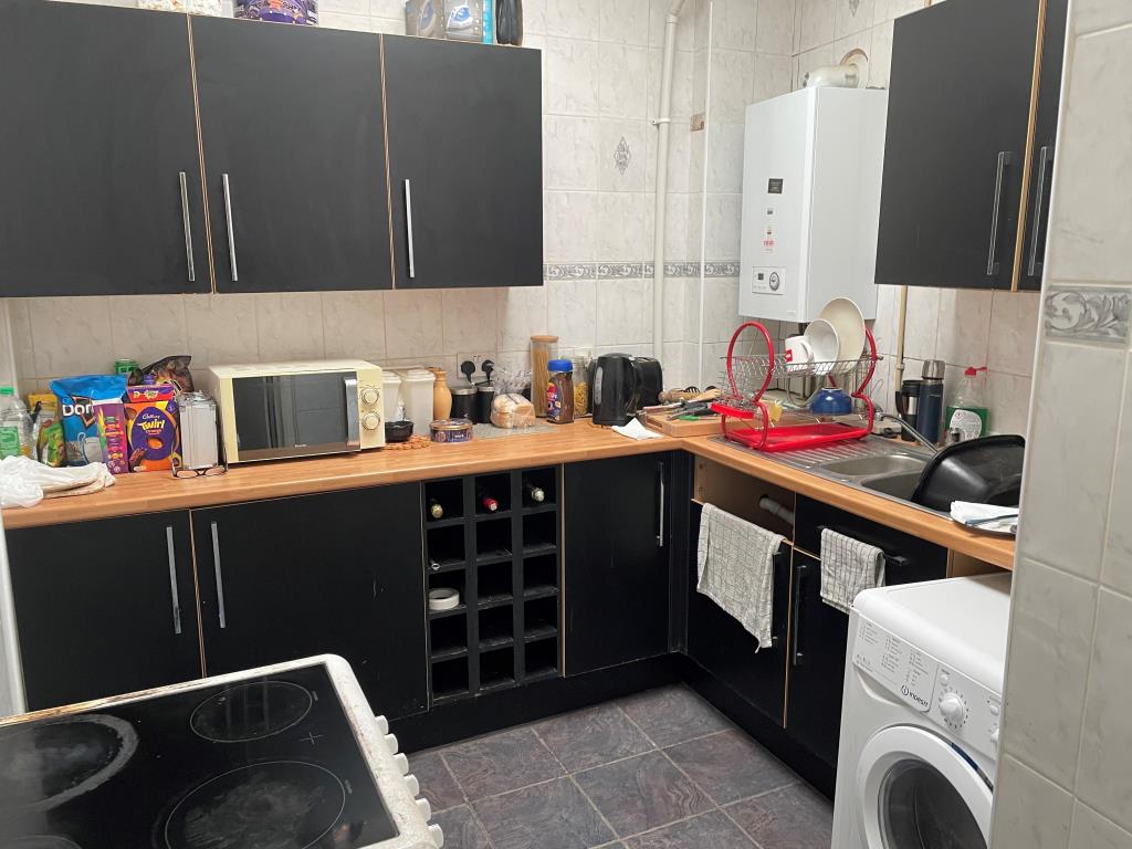 Lot: 79 - FREEHOLD SHOP AND FLAT WITH UPPER PARTS - view of kitchen with fitted units in rear flat
